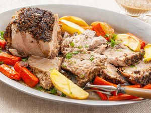 A platter with pork shoulder, carrots and potatoes.