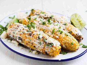 Mexican Street Corn topped with crema and cilantro on a plate