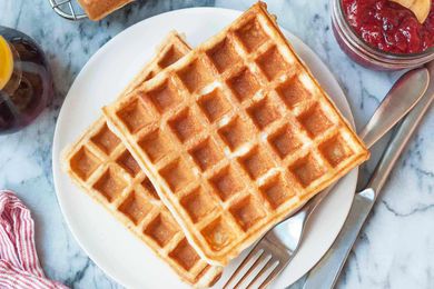 Easy waffle recipe served on a round plate with maple syrup