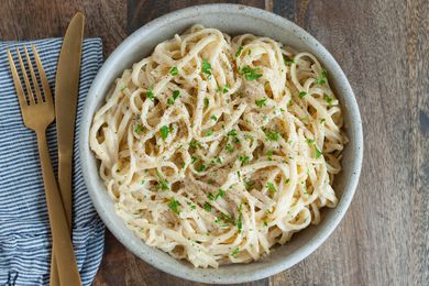 Easy Alfredo Sauce tossed with pasta in serving bowl