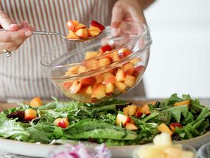 Salad recipe with peaches, goat cheese, and pistachios plate the salads