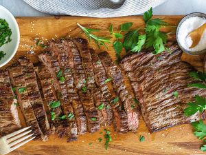 How to Cook Skirt Steak in a Pan - sliced steak with herbs on top