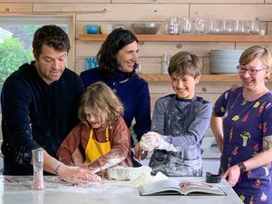 Misha and Vicki Collins with their kids and Emma Christensen making gnocchi