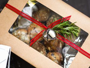 Muffins packed in a paper box with a red ribbon and bell