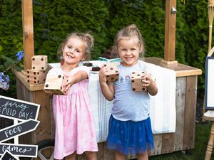 Two girls holding yard dice for backyard family activities.