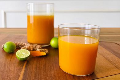 A glass and pitcher filled with Turmeric and Ginger Elixir.
