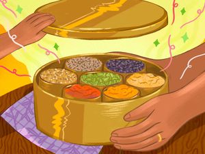 Hands opening a masala dabba filled with spices
