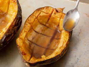 Baked acorn squash with sauce spooned overtop.