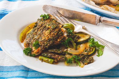 Parchment Baked Fish with Chermoula sauce on a plate with a knife and fork.