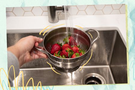 washing strawberries in a colander 