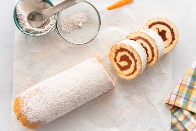 Roll Cake with Guava Jelly topped with powdered sugar and cut into a few slices.