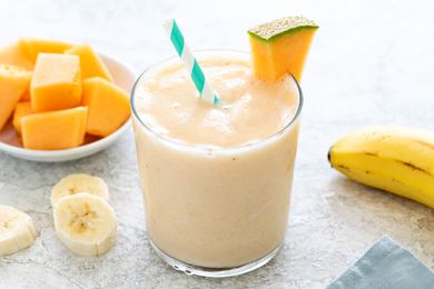 Simple cantaloupe smoothie in a glass and garnished with a slice cantaloupe.