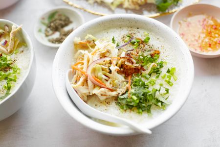 Chào Gá (Vietnamese Rice Porridge) in a Bowl Surrounded a Bowl of Sauce