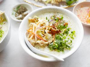 Chào Gá (Vietnamese Rice Porridge) in a Bowl Surrounded a Bowl of Sauce