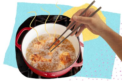 Woman with chopsticks picking up fried chicken