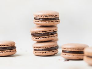 Double chocolate macarons stacked on a white background.
