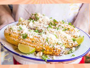 Someone holding a plate filled with elotes