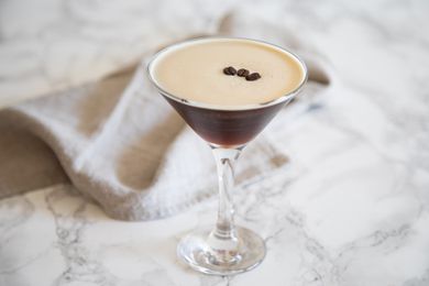 Side view of an Espresso Martini Drink on a marble background.