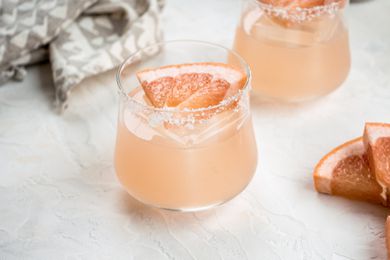 Two delicious grapefruit margaritas garnished with a grapefruit wedge.