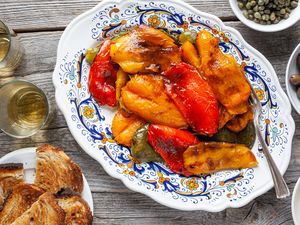 Platter of Grilled Peppers Surrounded by Olives, Capers, Olive Oil, and Toast