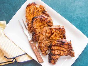 Grilled Pork Chops on Plate with Carving Fork