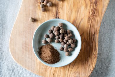 Whole and ground allspice on wooden cutting board