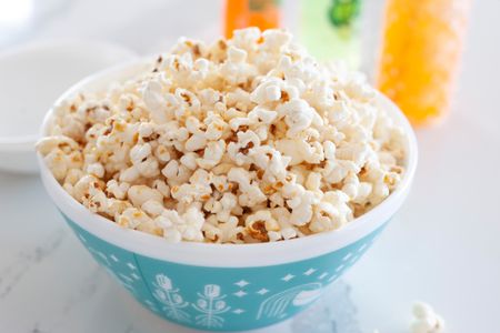 Side view of easy kettle corn in a teal bowl.