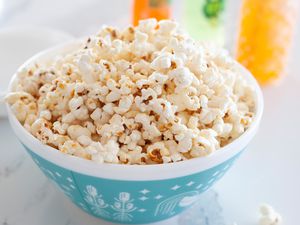 Side view of easy kettle corn in a teal bowl.