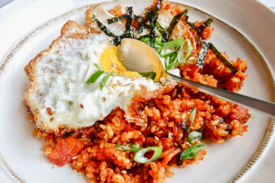 Kimchi fried rice with a fried egg served on a white plate.