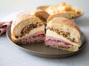 A Plate with Quarters of a Classic Muffuletta Sandwich Made with Cold Cuts, Cheese, and Olives