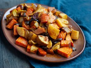 Quick and easy roasted vegetables on a platter with a teal linen underneath.