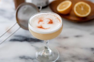 A coupe glass filled with an Authentic Peruvian Pisco Sour.