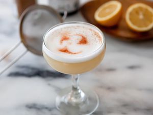 A coupe glass filled with an Authentic Peruvian Pisco Sour.