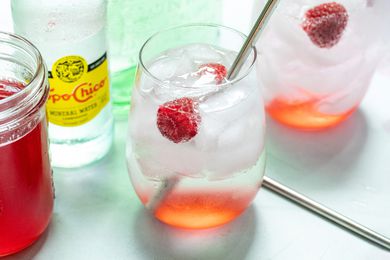 Raspberry Ranch water in two glasses and garnished with raspberries.