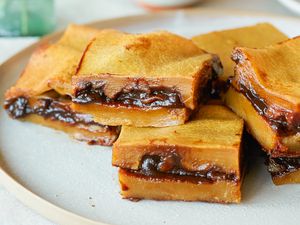 Side view of red bean paste rice cake stacked on a plate.
