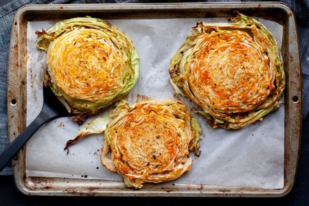 Overhead view of roasted cabbage steaks on a baking sheet.