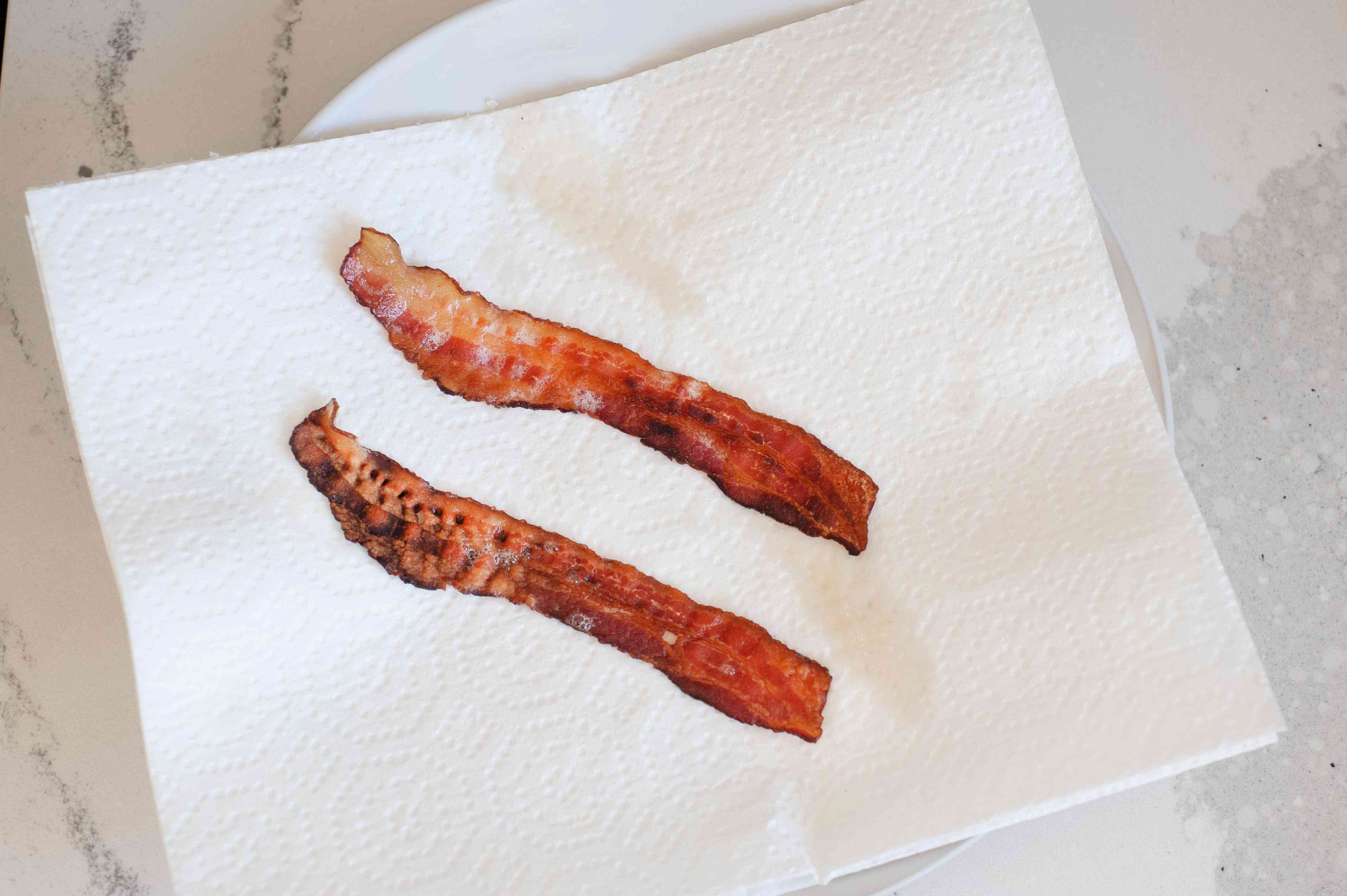Bacon draining on a paper towel to make summer-y salad with stone fruit and frisée