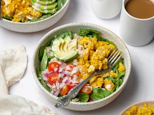 A vegan bowl with tofu, greens, and avocado.