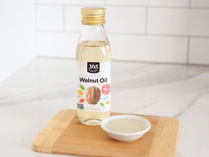 Walnut oil on wood cutting board white background