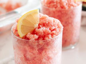 Two glasses with watermelon granita topped with lemon slice.