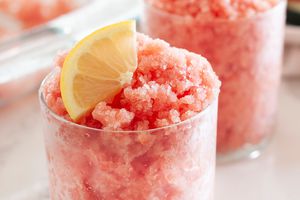 Two glasses with watermelon granita topped with lemon slice.