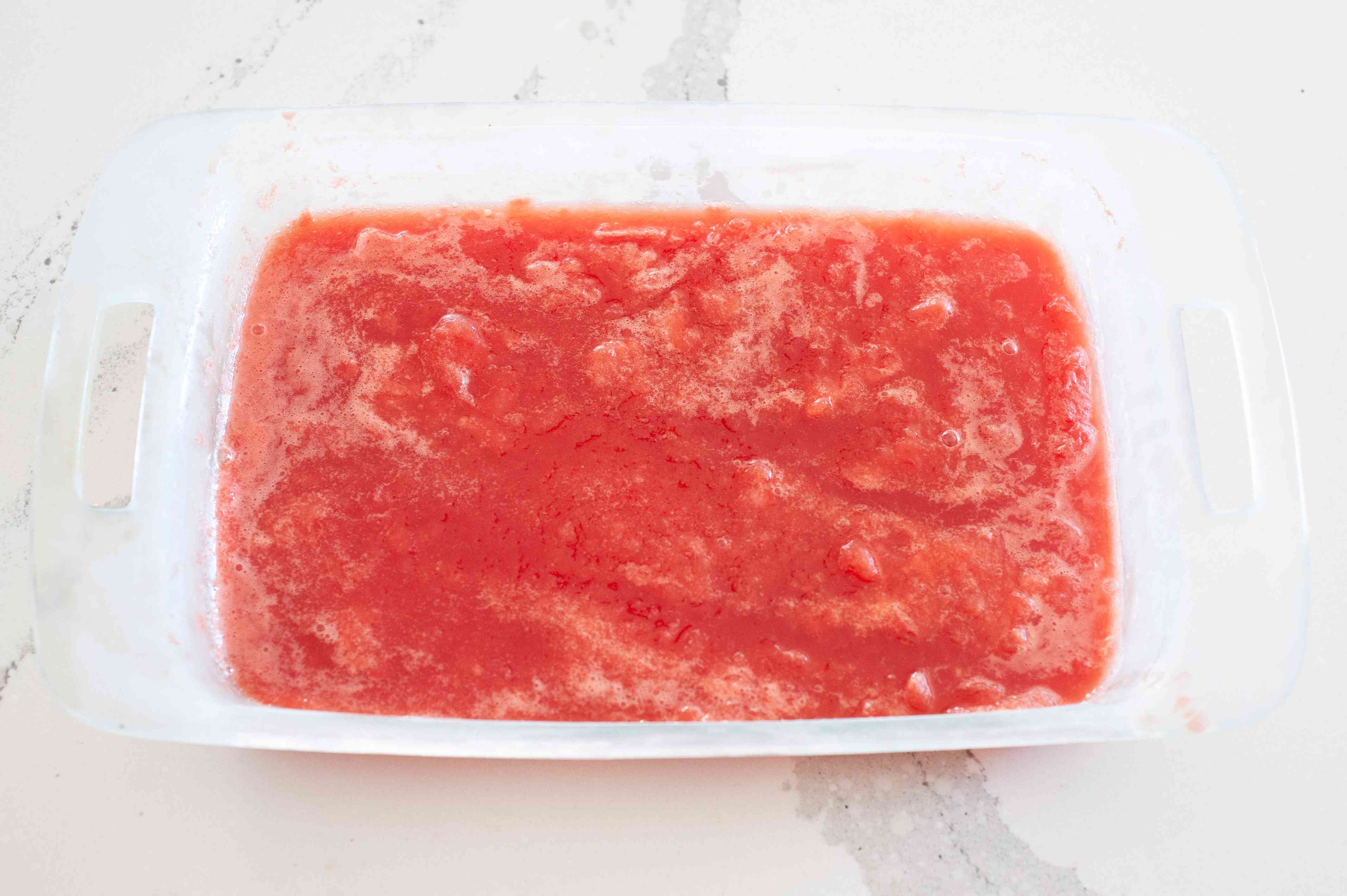 Watermelon liquid in a baking dish to make a watermelon granita recipe.