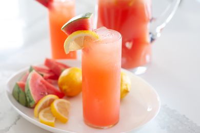 Whole lemon and watermelon lemonade in tall glasses and garnished with lemon and watermelon.
